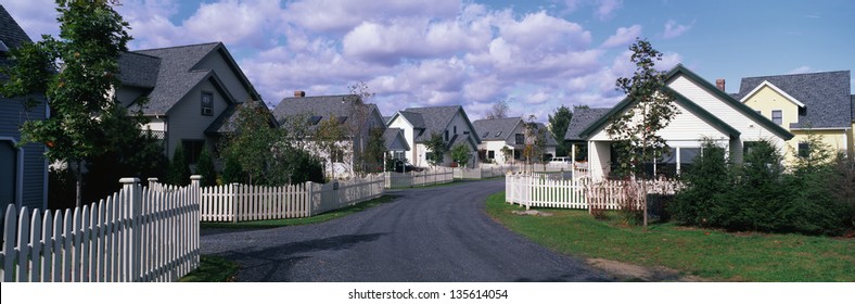 Suburban houses with white picket fence along a street in Maine, New England