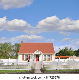 Suburban Middle Class Country Bungalow Cottage Home with White Picket Fence Beautiful Blue Cloudy Sky