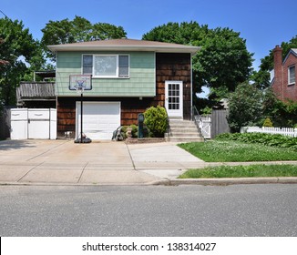 Suburban Middle Class Home In Residential Neighborhood Basketball Hoop In Driveway