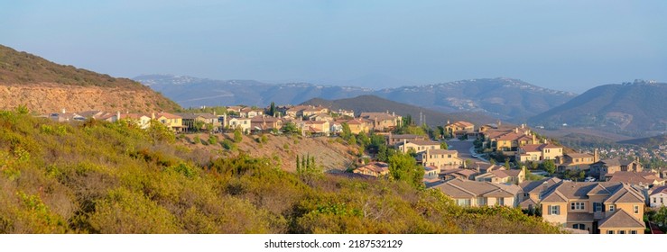 Suburban neighborhood on top of the mountains in Double Peak Park at San Marcos, California. There are large houses on a mountain on the left against the mountains at the back with residences on top. - Shutterstock ID 2187532129