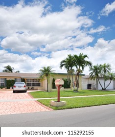 Suburban Ranch Home Mailbox Brick Driveway Car Parked Residential Neighborhood Blue Sky Clouds USA