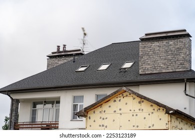 Suburban stucco house and TV antenna  balcony   drainage system metal roof  Roof gutter pipeline system  House rain gutter and holders   downspout pipes  snow retainers against sky