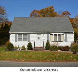 Suburban White And Gray Cape Cod Style Home Autumn Day Sunny Clear Blue Sky Residential Neighborhood USA