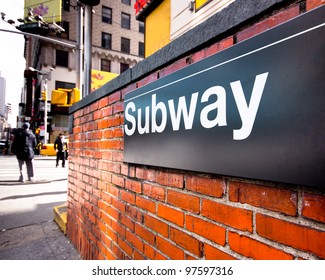 Subway entrance sign at a typical New York City intersection