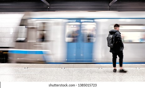 subway train arriving to modern metro station with male passenger person waiting on platform blurred background side view of city transportation underground station with motion car and people