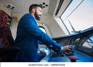 Subway Train Driver And Operator. Professional Driver Sitting In Cockpit And Operating High Speed Train.