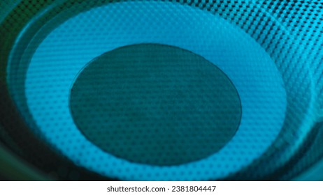 Subwoofer with membrane neon blue light moving vibrating, macro sound bass circles, abstract background.