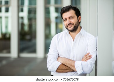 Succesful Man In White Shirt Standing Next To An Office Building In A Small Break Outside In A Corporate Area