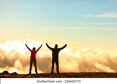 Success, Achievement And Accomplishment Concept With Hiking People Cheering And Celebrating Of Joy With Arms Raised Outstretched Up In The Sky On Trekking Hike Outside. Hikers Having Fun At Sunset.