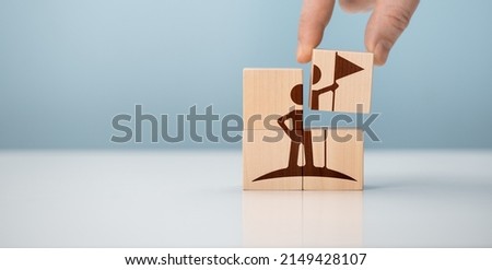 Success and achievement concept. Business success and goal achievement concept. Businessman hold wooden cubes with winer and leader icon on beautiful blue background, Market leader. copy space.