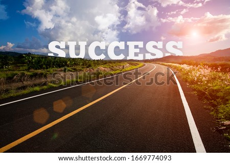 success behind the tree of empty asphalt road at golden sunset and beautiful blue sky. Success concept.
