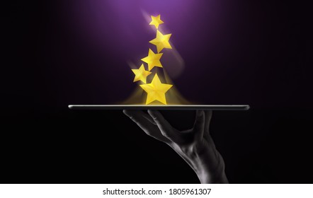Success in Business or Personal Talent Concept. Hand Raise Up a Digital tablet with Golden Five Star Awards - Shutterstock ID 1805961307