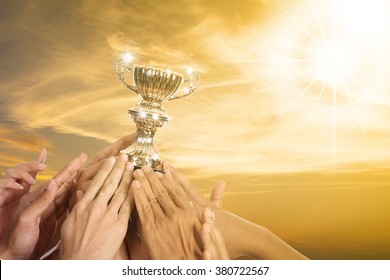 Success Business With Their Winner Trophy Holding By Hands. 