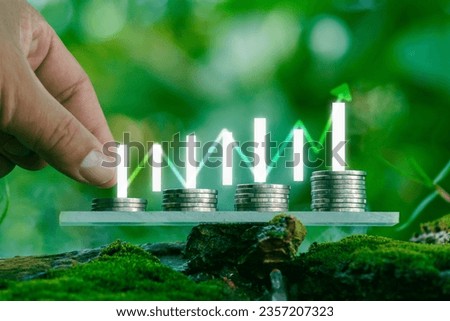 Success concept. Hand with pile of coins with growing virtual holographic stock chart icon. Stock Mutual Fund Returns, Returns, Investing, Retirement, Income Tax, Planning , Strategy business growth