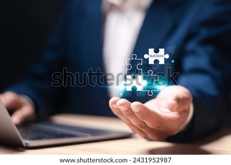 Success concept. Strategic planning towards business success goals. Businessman holding puzzle piece icon with success word on virtual screen.