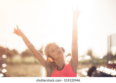 Success Fitness Winning Woman Concept With Earphones. Female Athlete Runner Cheering Arms Raised Up For Achievement In Weight Loss Or Life Goal.