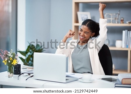 Success happens when you combine passion with ambition. Shot of a happy young businesswoman celebrating at her desk in a modern office.