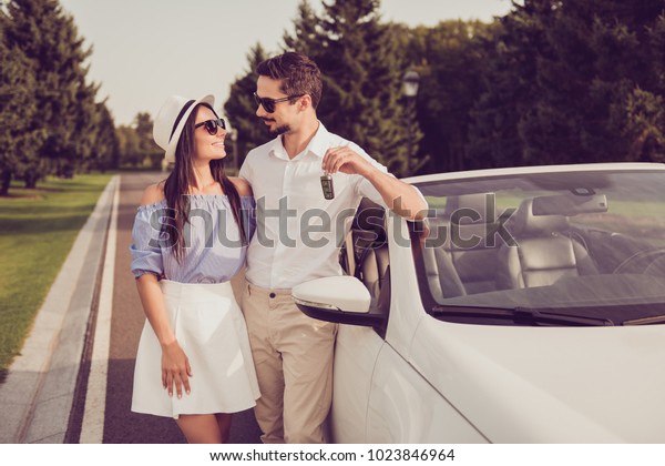 Success,\
happiness, sale, promotion, surprise, buyer, ownership, property,\
purchase, rent, sell cars concept. Married well dressed family\
bonding leaning the new vehicle outdoors in\
park