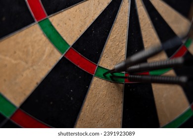 Success hitting target aim goal achievement concept background - three darts in bull's eye close up.