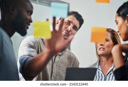 Success Is A Joint Effort. Cropped Shot Of A Group Of Business Colleagues Brainstorming On A Glass Wipe Board In Their Office.