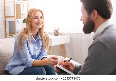 Success of life coaching. Smiling woman talking to professional psychological consultant, talking about her achievements