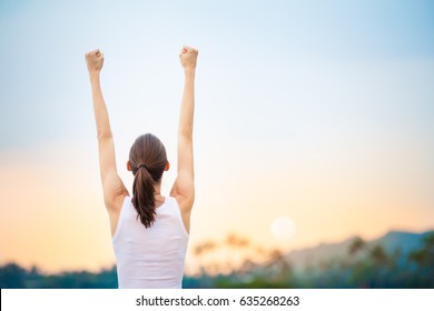 Success and life goals concept. Strong and confident woman with arms in the air. 