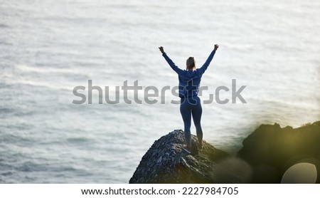 Success, ocean and rock with woman hiking for travel, freedom or training vacation. Heath, workout and silhouette with girl athlete on landscape adventure for winner, motivation or exercise in nature