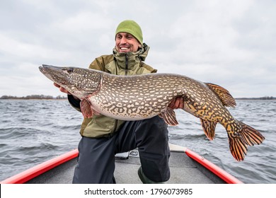 Success pike fishing. Happy fisherman with big fish trophy at boat - Shutterstock ID 1796073985