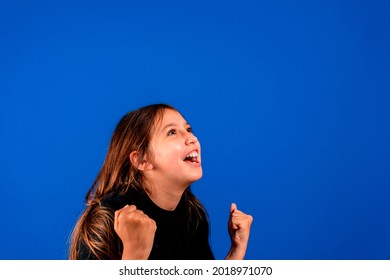 Success. Portrait winning successful little girl happy ecstatic celebrating being winner isolated blue background. Positive human emotion facial expression body language life achievement concept.