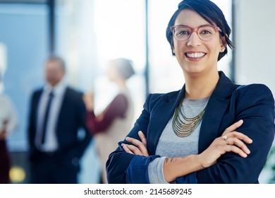 Success Is Second Nature To Me. Cropped Shot Of A Businesswoman Standing With Her Arms Crossed And Her Colleagues In The Background.