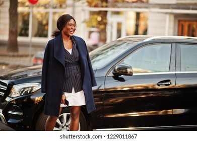 Success Stylish African American Woman In Coat Against Black Business Suv Car.