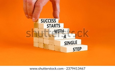 Success symbol. Concept words Success starts with a single step on wooden block. Beautiful orange table orange background. Businessman hand. Business success starts with single step concept Copy space