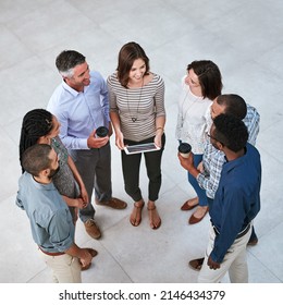 Success Is A Team Effort. High Angle Shot Of Businesspeople Talking In The Lobby Of Their Office.