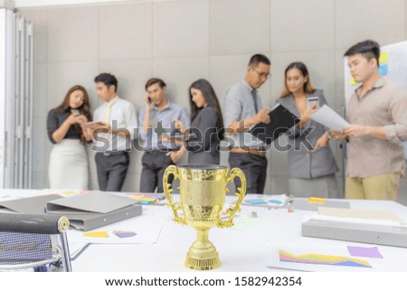 Success teamwork concept, Selective focus of Trophy with blurred group of business people team brainstorming at meeting room