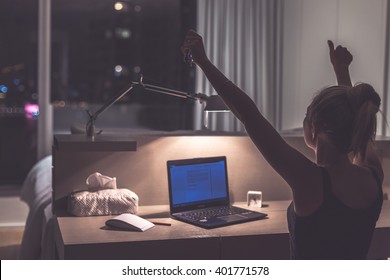 Success, victory or meeting deadline concept. Young,excited caucasian woman or teenager is holding her hands up in the air. Female teenager working late at night in her room. Success concept. - Shutterstock ID 401771578