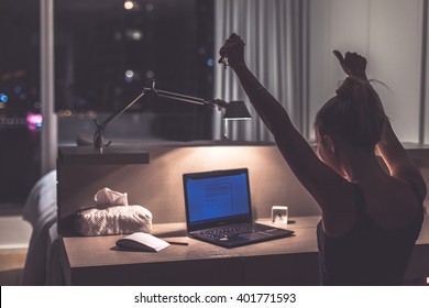 Success, victory or meeting deadline concept. Young,excited caucasian woman or teenager is holding her hands up in the air. Female teenager working late at night in her room. Success concept. - Shutterstock ID 401771593