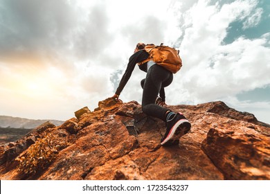 Success woman hiker hiking on sunrise mountain peak - Young woman with backpack rise to the mountain top. Discovery Travel Destination Concept