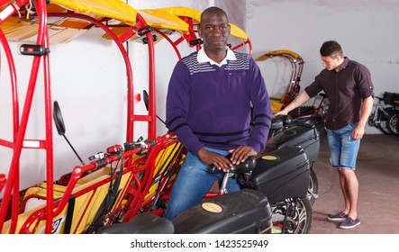 Successful African American driver of pedicab offering touristic tour