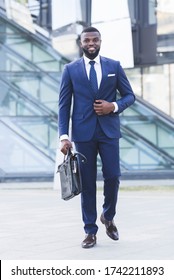 Successful African Businessman Going On Business Meeting Holding Briefcase Walking In Urban Area In City. Vertical, Full Length