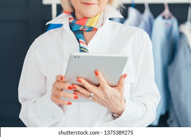 Successful Aged Woman. Clothes Boutique Business. Personal Fashion Stylist. Busy Senior Lady With Tablet At Showroom.