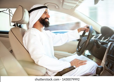 Successful Arab Saudi Businessman Riding His Car Or Driving Full Of Emotions At Sunny Day. Male Model As An Enterpreneur. Concept Of Business, Finance, Modern Technologies, Start Up, Economy.