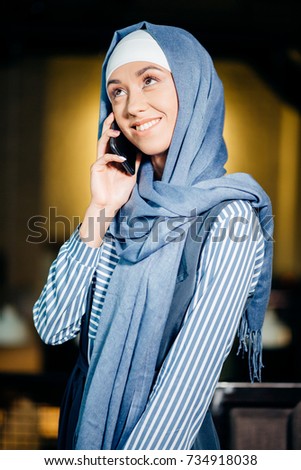 Successful Arab woman. Arab businesswoman wearing hijab talking on cell phone and looking at the camera