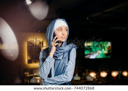 Successful Arab woman. Arab businesswoman wearing hijab talking on cell phone and looking at the camera