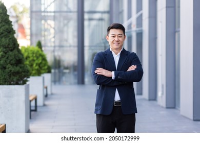 Successful Asian Boss Near The Office Looks At The Camera With Crossed Arms Smiles And Rejoices In Success