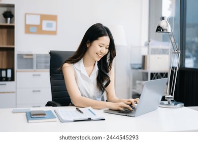 Successful Asian Businesswoman Analyzing Finance on Tablet and Laptop at modern Office Desk tax, report, accounting, statistics, and analytical research concept - Powered by Shutterstock