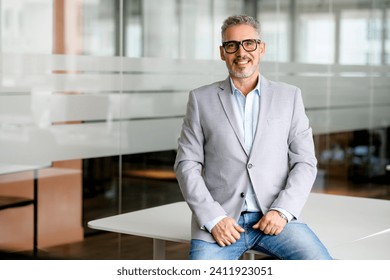 Successful authoritative confident mature grey-haired adult male entrepreneur businessman professional in formal wear standing at the modern home office, looking at camera - Powered by Shutterstock