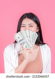 Successful Beautiful Asian Business Young Woman Holding Money US Dollar Bills In Hand On Pink Background , Business Concept