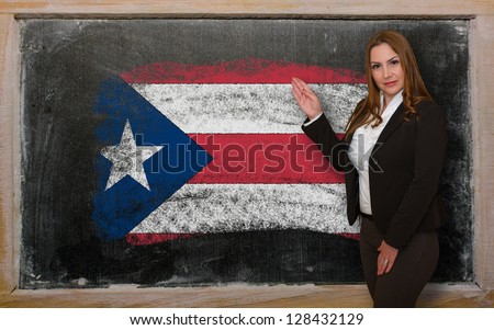 Successful, beautiful and confident woman showing flag of PuertoRico on blackboard for marketing research, presentation and tourist advertising