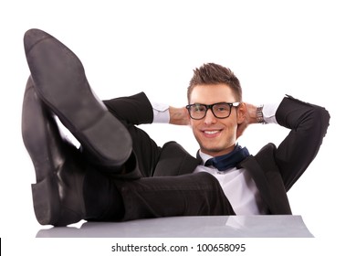 Successful business man relaxing over his desk, isolated in white background