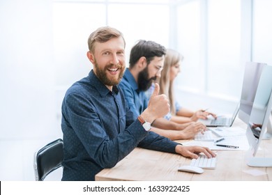 successful business man sitting at his Desk and looking at the camera - Shutterstock ID 1633922425